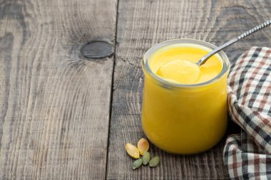 Ahşap masada cam kavanozda kabak püresi 