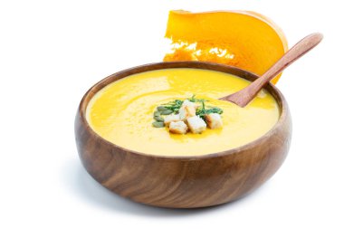 Beyaz üzerine izole edilmiş kızarmış ekmeklerle servis edilen kabak kremalı çorba. 