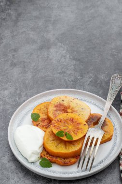 Gri arkaplanda fırında karamelize edilmiş hurma parçaları. 