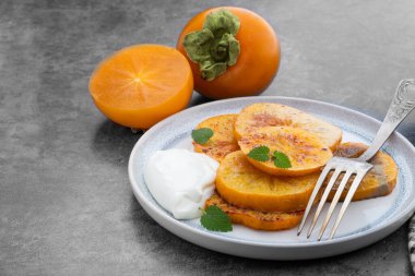 Gri arkaplanda fırında karamelize edilmiş hurma parçaları. 