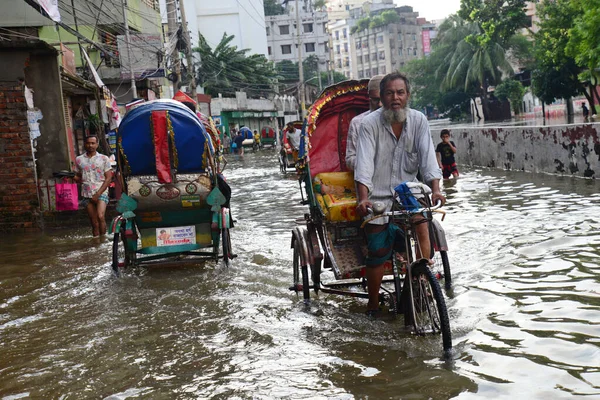リックショーは昨日の夜にダッカの浸水した通りを乗客と一緒に運転しようとします大雨は 2022年10月25日にバングラデシュのダッカで強いサイクロンSitrangの影響を引き起こしました — ストック写真