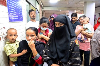 Akrabalar, 31 Ekim 2022 'de Bangladeş' in Dhaka kentinde tedavi için Dhaka çocuk hastanesine gelen çocuk hastalarıyla birlikte acil servis kapısının önünde toplanıyorlar. Ocak ayından bu yana yaklaşık 38024 kişi hastaneye kaldırıldı ve 141 kişi hayatını kaybetti.