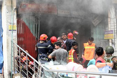 İtfaiyeciler, güvenlik güçleri ve kurtarma ekipleri, 15 Nisan 2023 'te Bangladeş' in Dhaka kentindeki Yeni Yemek Pazarı giyim pazarında çıkan yangını söndürmeye çalışıyorlar. Binlerce giyim mağazası yangında yandı ve otobüslere önemli bir darbe vurdu.