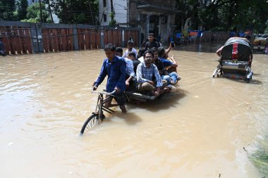 Araçlar sürmeye çalışıyor ve vatandaşlar 22 Eylül 2023 'te Bangladeş' teki Dhaka caddelerinde yürüyorlar. Dün gece şiddetli muson yağmurlarından sonra Bangladeş 'in Dhaka şehrinin birçok bölgesinde aşırı su tomrukçuluğuna neden oldu. Yollar alt tabakaydı.