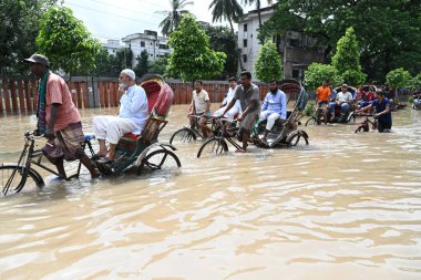 Araçlar sürmeye çalışıyor ve vatandaşlar 22 Eylül 2023 'te Bangladeş' teki Dhaka caddelerinde yürüyorlar. Dün gece şiddetli muson yağmurlarından sonra Bangladeş 'in Dhaka şehrinin birçok bölgesinde aşırı su tomrukçuluğuna neden oldu. Yollar alt tabakaydı.