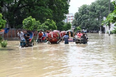 Araçlar sürmeye çalışıyor ve vatandaşlar 22 Eylül 2023 'te Bangladeş' teki Dhaka caddelerinde yürüyorlar. Dün gece şiddetli muson yağmurlarından sonra Bangladeş 'in Dhaka şehrinin birçok bölgesinde aşırı su tomrukçuluğuna neden oldu. Yollar alt tabakaydı.