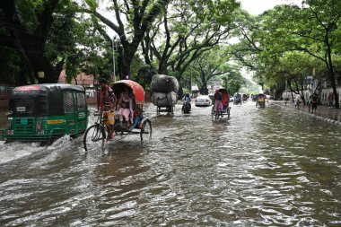 Araçlar sürmeye çalışıyor ve vatandaşlar 22 Eylül 2023 'te Bangladeş' teki Dhaka caddelerinde yürüyorlar. Dün gece şiddetli muson yağmurlarından sonra Bangladeş 'in Dhaka şehrinin birçok bölgesinde aşırı su tomrukçuluğuna neden oldu. Yollar alt tabakaydı.