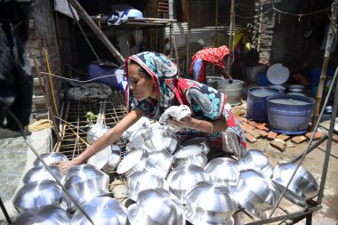 Kadınlar, Bangladeş 'in Dhaka kentinde alüminyum tencere üretim fabrikasında çalışır ve her biri günde sadece 300 Taka ($3,87) kazanır. 20 Haziran 201