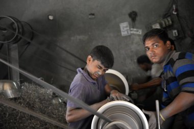 Eski Dhaka 'daki alüminyum esrar fabrikasında çalışan çocuklar. Çocuklar 200 taka (3 ABD $) haftalık ücret için günde 10 saat tehlikeli koşullarda çalışırlar. Dhaka, Bangladeş. 20 Haziran 2015 'te