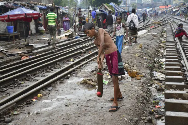 Bangladeş, Dhaka 'da derme çatma evlerle çevrili demiryolu raylarında kriket oynuyorlar. 13 Haziran 2015 'te