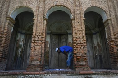 Panam şehrinin manzarasında, bir adam Bangladeş 'in başkenti Dhaka' nın Narayangong eteklerindeki haritada dua ediyor. 21 Haziran 2015 'te. Panam şehri, 19. yüzyılda başta Hindu kumaş tüccarları olmak üzere üst orta sınıf Bengalli işadamları tarafından inşa edildi.. 