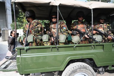 Bangladesh Army personnel sit in the back of a vehicle in Dhaka, Bangladesh, on January 3, 2024, to assist local administrations ahead of the upcoming general election on January 7. The armed forces are being deployed nationwide in preparation for th