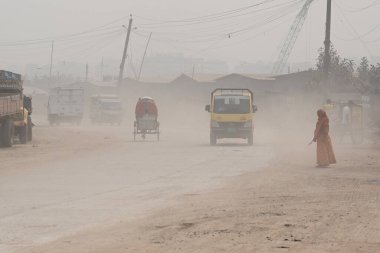 İnsanlar 30 Ocak 2024 'te Bangladeş' in Dhaka şehrinde tozlu bir yolda harekete geçtiler. Hava Kalite Endeksine göre, Dhaka City 'nin Havası' çok sağlıksız 'olarak sınıflandırıldı ve vatandaşlar için ciddi sağlık riskleri oluşturdu.