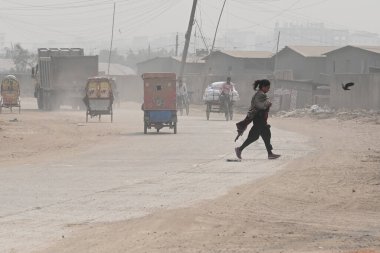 İnsanlar 30 Ocak 2024 'te Bangladeş' in Dhaka şehrinde tozlu bir yolda harekete geçtiler. Hava Kalite Endeksine göre, Dhaka City 'nin Havası' çok sağlıksız 'olarak sınıflandırıldı ve vatandaşlar için ciddi sağlık riskleri oluşturdu.