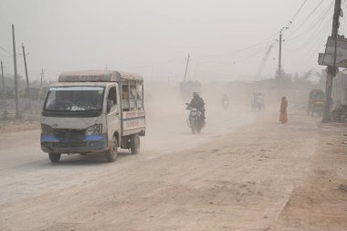 İnsanlar 30 Ocak 2024 'te Bangladeş' in Dhaka şehrinde tozlu bir yolda harekete geçtiler. Hava Kalite Endeksine göre, Dhaka City 'nin Havası' çok sağlıksız 'olarak sınıflandırıldı ve vatandaşlar için ciddi sağlık riskleri oluşturdu.