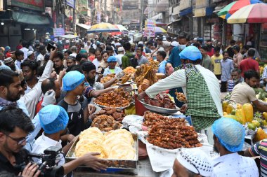 Sokak satıcısı, 12 Mart 2024 'te Bangladeş' in Dhaka kentindeki geleneksel iftar pazarında kutsal Ramazan ayı gündüz orucunu kırmak için iftar yiyeceği satıyor.