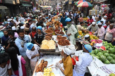 Sokak satıcısı, 12 Mart 2024 'te Bangladeş' in Dhaka kentindeki geleneksel iftar pazarında kutsal Ramazan ayı gündüz orucunu kırmak için iftar yiyeceği satıyor.