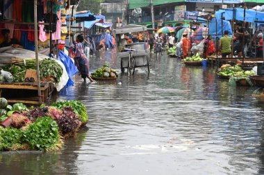 Sebze satıcısı, 19 Mart 2024 'te Bangladeş' in Dhaka kentindeki Karwan Bazar 'da su dolu pazarda müşteri bekliyor. Muson yağmurlarının ardından Bangladeş 'in başkenti Dhaka' daki bölgenin çoğu sular altında kaldı..