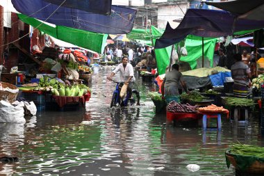 Sebze satıcısı, 19 Mart 2024 'te Bangladeş' in Dhaka kentindeki Karwan Bazar 'da su dolu pazarda müşteri bekliyor. Muson yağmurlarının ardından Bangladeş 'in başkenti Dhaka' daki bölgenin çoğu sular altında kaldı..