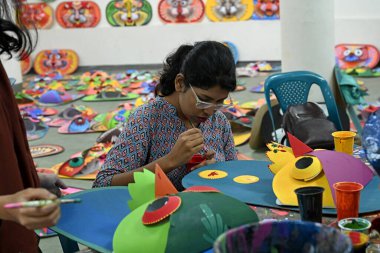 Dhaka Üniversitesi Güzel Sanatlar Fakültesi öğrencisi 30 Mart 2024 'te Bangladeş' in Dhaka kentinde yapılacak Bengali Yeni Yılı 'nı renklendirmek için maske boyuyor. Pahela Baishakh (Bangla ayının ilk günü) geri döndürülebilir 