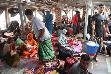 Yolcular, Bangladeş 'in başkenti Dhaka' daki Sadarghat Fırlatma Terminali 'ndeki bayram bayramını kutlamak üzere 4 Nisan 2024' te başkentteki köylerine dönmek üzere feribot terminalinde toplanıyorlar..