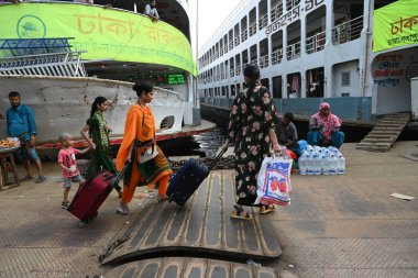 Yolcular, Bangladeş 'in başkenti Dhaka' daki Sadarghat Fırlatma Terminali 'ndeki bayram bayramını kutlamak üzere 4 Nisan 2024' te başkentteki köylerine dönmek üzere feribot terminalinde toplanıyorlar..