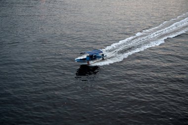 İnsanlar 26 Nisan 2024 'te Bangladeş' in Dhaka kentindeki Buriganga Nehri 'nin zifiri karanlık sularından geçen bir tekneye biniyorlar.. 
