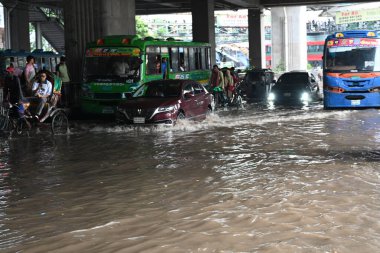 7 Haziran 202 'de Bangladeş, Dhaka' da sağanak yağışların yol açtığı sular altında kalmış caddelerde araçlar ve çekçekçekçekçekler yolcuları götürmeye çalışıyor.
