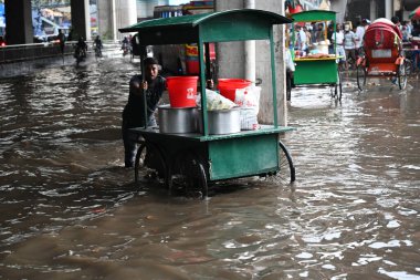 Vehicles and rickshaws are trying to drive with passengers through the waterlogged streets caused by heavy rainfalls in Dhaka, Bangladesh, on June 7, 202 clipart