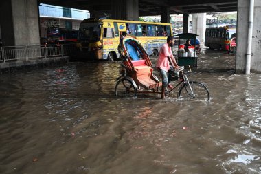7 Haziran 202 'de Bangladeş, Dhaka' da sağanak yağışların yol açtığı sular altında kalmış caddelerde araçlar ve çekçekçekçekçekler yolcuları götürmeye çalışıyor.