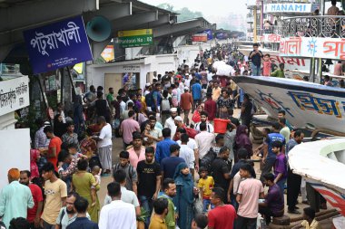 Yolcular, 14 Haziran 2024 'te Bangladeş' in Dhaka kentindeki Sadarghat Fırlatma Terminali 'nde düzenlenen Kurban Bayramı bayramını kutlamak üzere başkenti Dhaka' daki köylerine dönmek üzere feribot terminalinde toplanıyorlar.. 