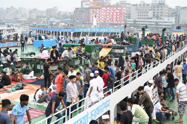 Yolcular, 14 Haziran 2024 'te Bangladeş' in Dhaka kentindeki Sadarghat Fırlatma Terminali 'nde düzenlenen Kurban Bayramı bayramını kutlamak üzere başkenti Dhaka' daki köylerine dönmek üzere feribot terminalinde toplanıyorlar.. 