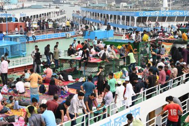 Yolcular, 14 Haziran 2024 'te Bangladeş' in Dhaka kentindeki Sadarghat Fırlatma Terminali 'nde düzenlenen Kurban Bayramı bayramını kutlamak üzere başkenti Dhaka' daki köylerine dönmek üzere feribot terminalinde toplanıyorlar.. 