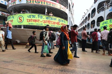 Yolcular, 14 Haziran 2024 'te Bangladeş' in Dhaka kentindeki Sadarghat Fırlatma Terminali 'nde düzenlenen Kurban Bayramı bayramını kutlamak üzere başkenti Dhaka' daki köylerine dönmek üzere feribot terminalinde toplanıyorlar.. 