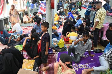 Yolcular, 14 Haziran 2024 'te Bangladeş' in Dhaka kentindeki Sadarghat Fırlatma Terminali 'nde düzenlenen Kurban Bayramı bayramını kutlamak üzere başkenti Dhaka' daki köylerine dönmek üzere feribot terminalinde toplanıyorlar.. 