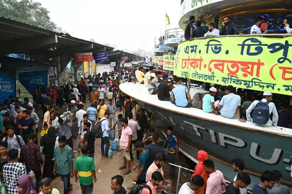 Yolcular, 14 Haziran 2024 'te Bangladeş' in Dhaka kentindeki Sadarghat Fırlatma Terminali 'nde düzenlenen Kurban Bayramı bayramını kutlamak üzere başkenti Dhaka' daki köylerine dönmek üzere feribot terminalinde toplanıyorlar.. 