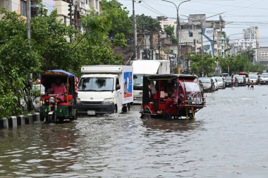 26 Haziran 2024 'te Bangladeş, Dhaka' da şiddetli muson yağmurlarının yol açtığı sular altında kalmış sokaklarda araçlar ve çekçekçekçekçekler yolcuları götürmeye çalışıyor.. 
