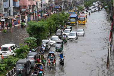 26 Haziran 2024 'te Bangladeş, Dhaka' da şiddetli muson yağmurlarının yol açtığı sular altında kalmış sokaklarda araçlar ve çekçekçekçekçekler yolcuları götürmeye çalışıyor.. 