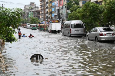 26 Haziran 2024 'te Bangladeş, Dhaka' da şiddetli muson yağmurlarının yol açtığı sular altında kalmış sokaklarda araçlar ve çekçekçekçekçekler yolcuları götürmeye çalışıyor.. 