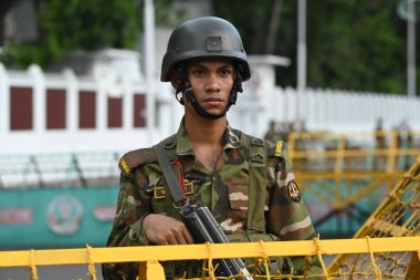 Bangladeş Ordusu askerleri, 8 Ağustos 2024 tarihinde Bangladeş 'in Dhaka kentinde yapılan geçici hükümetin yemin töreni sırasında başkanın resmi konutunun önünde nöbet tutuyorlar.. 