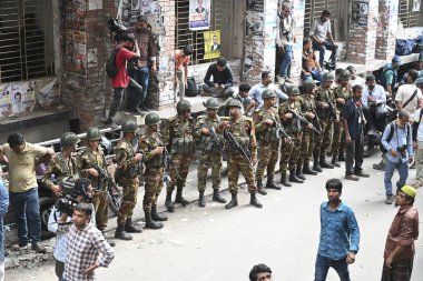 Bangladeş Ordusu askerleri eski hukuk bakanı Anisul Huq ve eski Başbakan Şeyh Hasina 'nın danışmanı Salman F Rahman, 14 Ağustos 2024' te Dhaka 'daki Başkent Sulh Ceza Hakimliği' ne (CMM) götürülürken nöbet tutuyorlar.