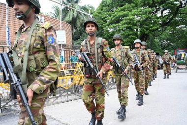 Bangladeş Ordusu askerleri, 26 Eylül 2024 'te Bangladeş' in Dhaka kentinde Hindu tanrısı Krishna 'nın doğumunu kutlayan Janmashtami festivaline katılan Hindu dindarlar geçit törenine eşlik ederler.. 