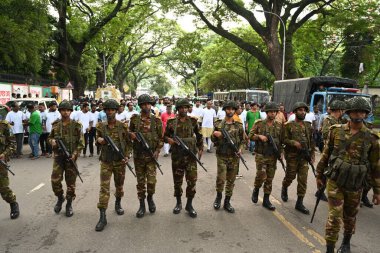 Bangladeş Ordusu askerleri, 26 Eylül 2024 'te Bangladeş' in Dhaka kentinde Hindu tanrısı Krishna 'nın doğumunu kutlayan Janmashtami festivaline katılan Hindu dindarlar geçit törenine eşlik ederler.. 