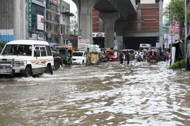 3 Eylül 2024 'te sağanak yağış neredeyse durgunluğa yol açtıktan sonra araçlar ve Rickshaw' lar Dhaka 'nın sulak sokaklarında yolcularla birlikte araba sürmeye çalışırlar.. 