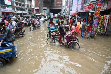 Vehicles and Rickshaws try driving with passengers through the waterlogged streets of Dhaka after heavy rainfalls caused almost-standstill, on September 3, 2024.  clipart