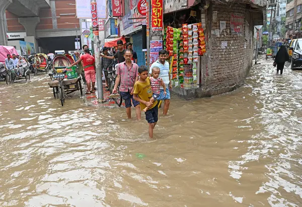 3 Eylül 2024 'te sağanak yağış neredeyse durgunluğa yol açtıktan sonra araçlar ve Rickshaw' lar Dhaka 'nın sulak sokaklarında yolcularla birlikte araba sürmeye çalışırlar.. 