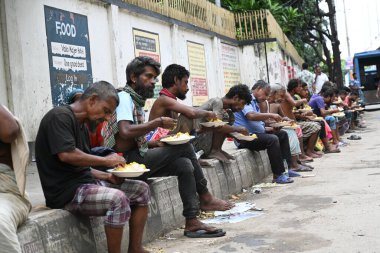 Yoksul insanlar 10 Eylül 2024 'te Dhaka, Bangladeş' te yol kenarında yemek yiyorlar. 