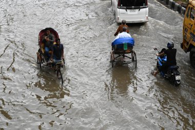 3 Ekim 2024 'te Bangladeş' te sağanak yağış neredeyse durgunluğa yol açtıktan sonra araçlar ve Rickshawlar Dhaka şehrinin sulak sokaklarında yolcularla birlikte araba sürmeye çalışıyor.. 
