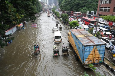 3 Ekim 2024 'te Bangladeş' te sağanak yağış neredeyse durgunluğa yol açtıktan sonra araçlar ve Rickshawlar Dhaka şehrinin sulak sokaklarında yolcularla birlikte araba sürmeye çalışıyor.. 