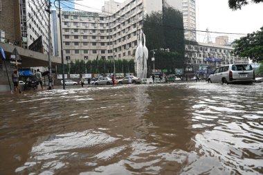 5 Ekim 2024 'te Bangladeş' te sağanak yağış neredeyse durgunluğa yol açtıktan sonra, araçlar ve Rickshawlar Dhaka şehrinin sulak sokaklarında yolcularla birlikte sürmeye çalışırlar.. 